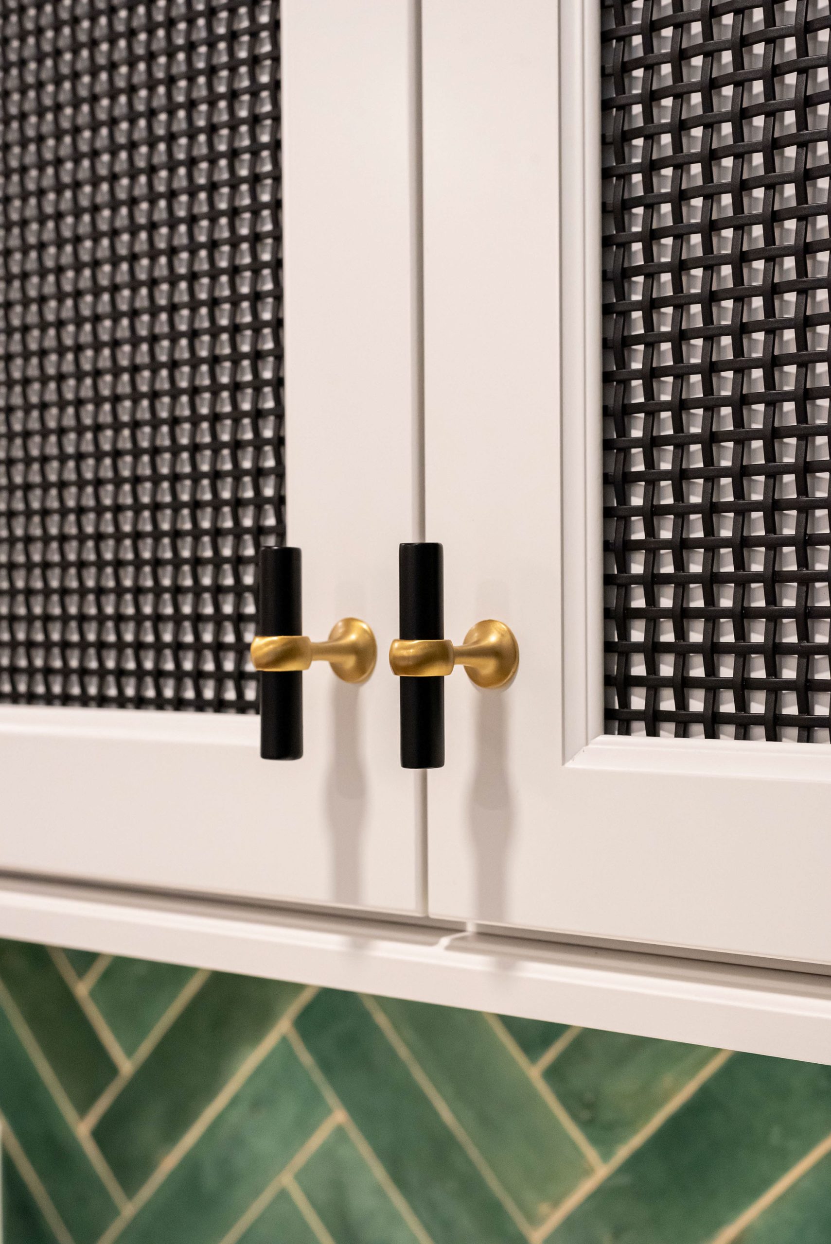 Black and gold cabinet handles provide the perfect accent colors to a dark and modern kitchen design.