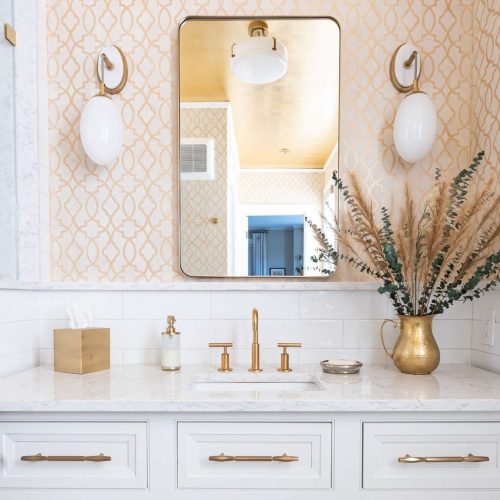 A bright and chic bathroom design with white and gold tones.